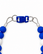 Close-up of the Blue Pawsch beaded dog necklace showing the blue clasp, silver rings, cable, crimps, and blue and white beads