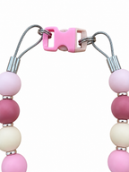 Close-up of the Neutral Pawsch beaded dog necklace showing the pink clasp, silver rings, cable, crimps, and pastel beads on a white background