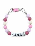 Blush, mauve, lavender and cream Pawsch beaded dog necklace personalized with the name PAWSE on a white background